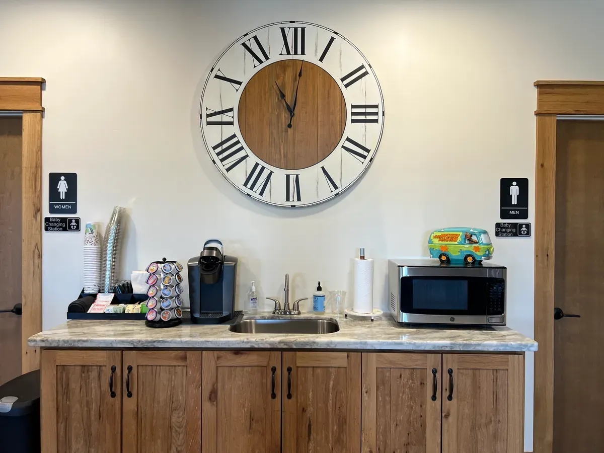 Counter with a coffee machine, microwave, and cups
